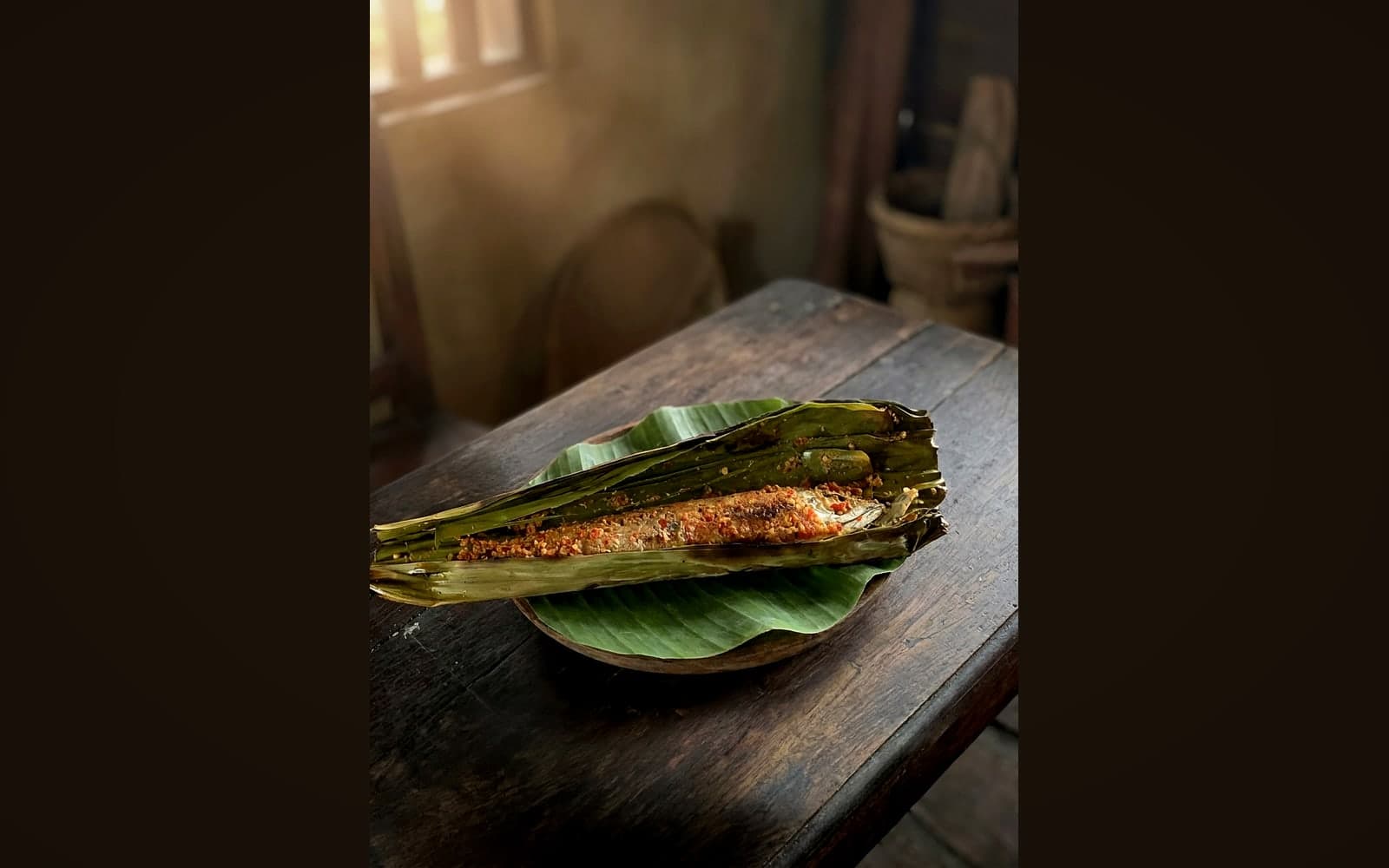 Ganzer gegrillter Fisch im gefalteten Bananenblatt — KI-generiertes Symbolbild