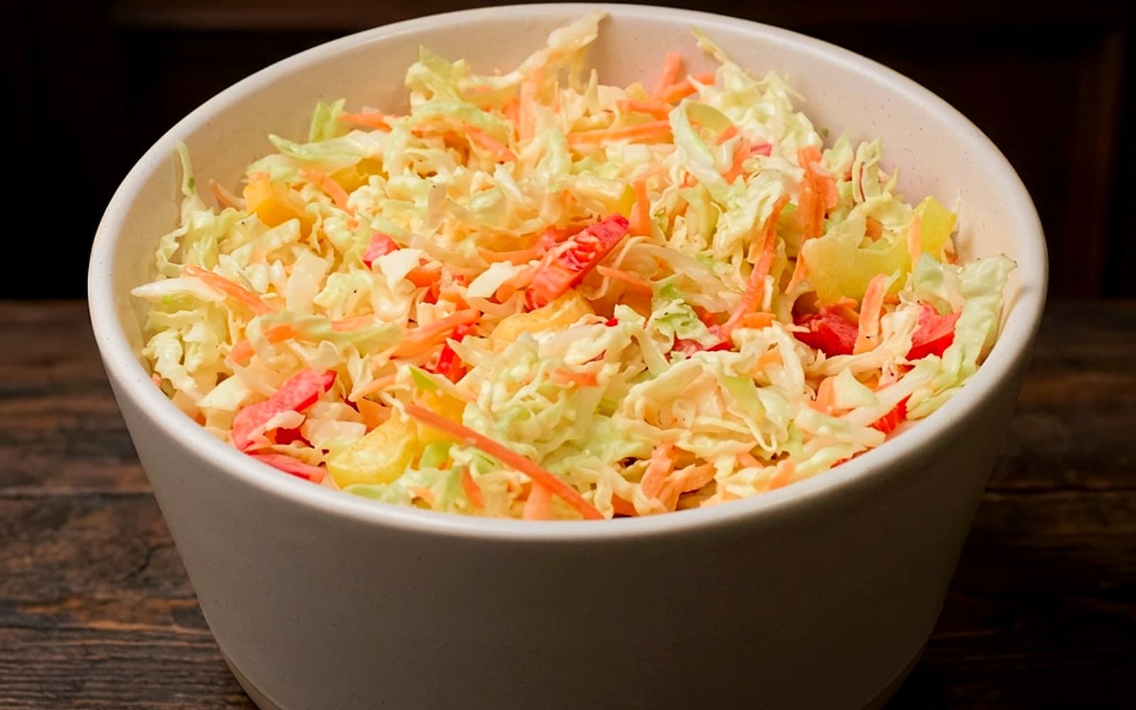 Schüssel mit cremigem Krautsalat aus fein geschnittenem Weißkohl und Karotte — KI-generiertes Symbolbild