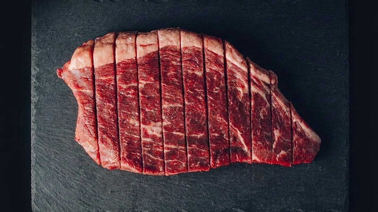 Rohes Rindfleisch in Streifen auf dunklem Untergrund